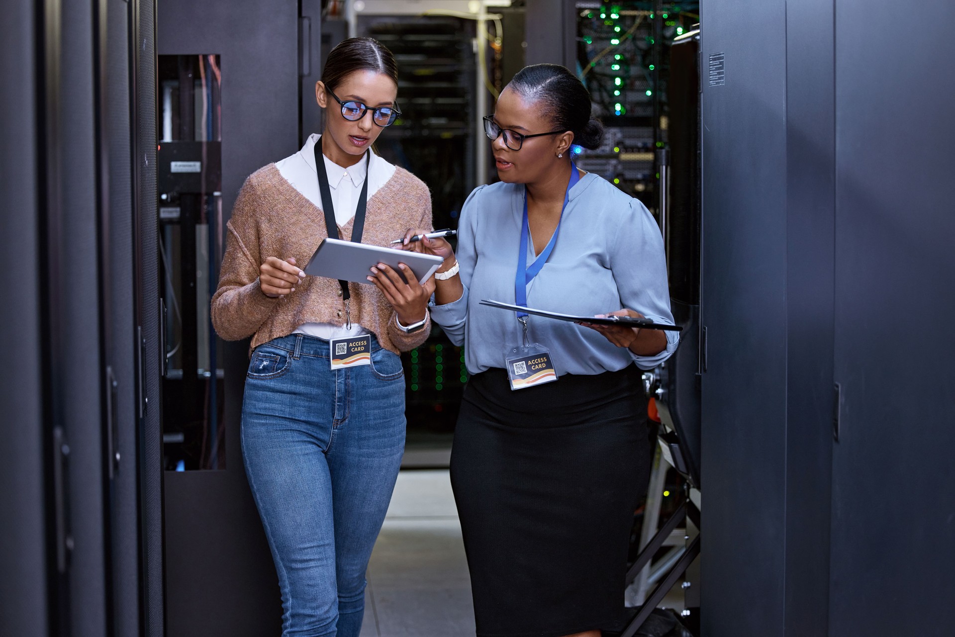 Cropped shot of two attractive young female computer programmers working together in a server room Cropped shot of two attractive young female computer programmers working together in a server room