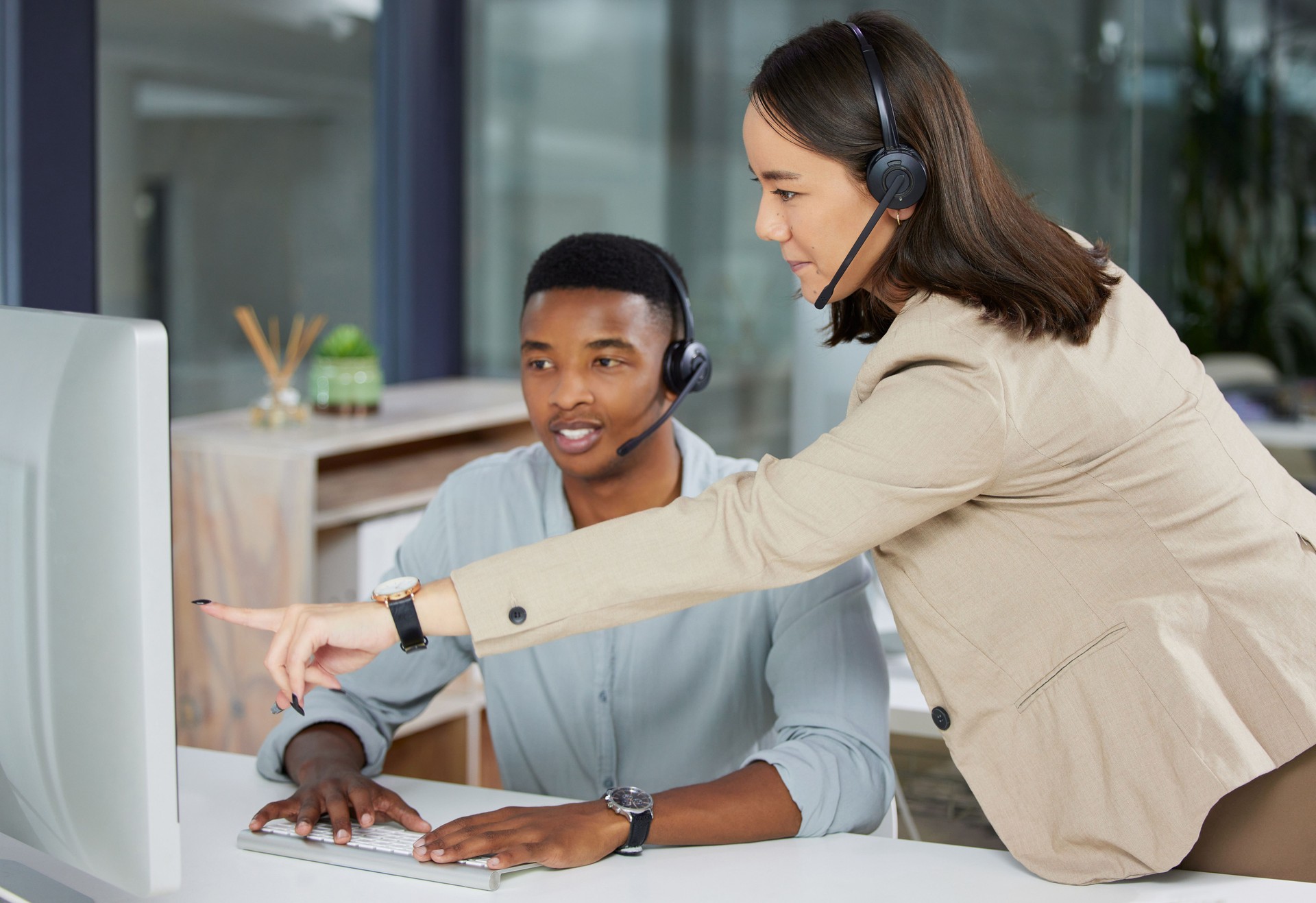Shot of a young man and woman using a computer while working in a call centre Shot of a young man and woman using a computer while working in a call centre