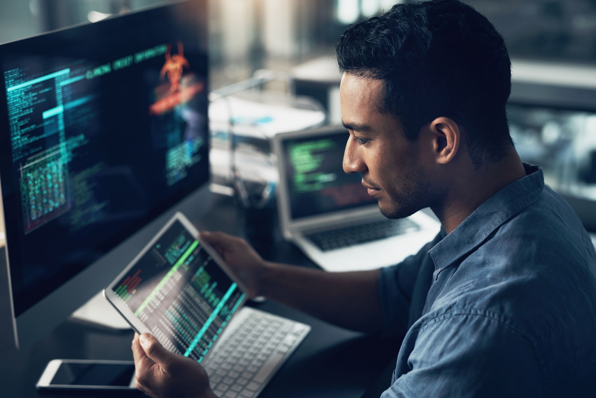 Shot of a young man using his digital tablet and computer in a modern office Shot of a young man using his digital tablet and computer in a modern office
